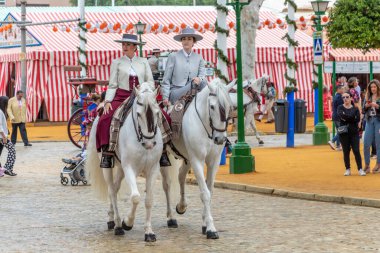 Seville, İspanya - 5 Mayıs 2019: Ata binen ve Seville 'deki Nisan Fuarı' nı (Feria de Sevilla) kutlayan güzel kadınlar. Seville Nisan Fuarı 5 Mayıs 2019, Sevilla, İspanya