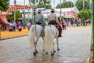 Seville, İspanya - 5 Mayıs 2019: Ata binen ve Seville 'deki Nisan Fuarı' nı (Feria de Sevilla) kutlayan güzel kadınlar. Seville Nisan Fuarı 5 Mayıs 2019, Sevilla, İspanya