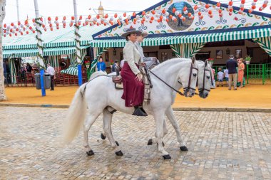 Seville, İspanya - 5 Mayıs 2019: Ata binen ve Seville 'deki Nisan Fuarı' nı (Feria de Sevilla) kutlayan güzel kadınlar. Seville Nisan Fuarı 5 Mayıs 2019, Sevilla, İspanya