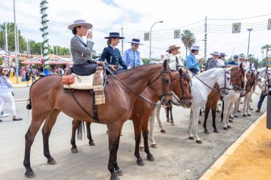 Seville, İspanya - 5 Mayıs 2019: Ata binen ve Seville 'deki Nisan Fuarı' nı (Feria de Sevilla) kutlayan güzel kadınlar. Seville Nisan Fuarı 5 Mayıs 2019, Sevilla, İspanya