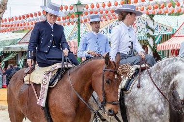 Seville, İspanya - 5 Mayıs 2019: Ata binen ve Seville 'deki Nisan Fuarı' nı (Feria de Sevilla) kutlayan güzel kadınlar. Seville Nisan Fuarı 5 Mayıs 2019, Sevilla, İspanya