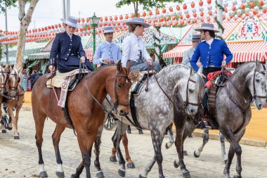 Seville, İspanya - 5 Mayıs 2019: Ata binen ve Seville 'deki Nisan Fuarı' nı (Feria de Sevilla) kutlayan güzel kadınlar. Seville Nisan Fuarı 5 Mayıs 2019, Sevilla, İspanya