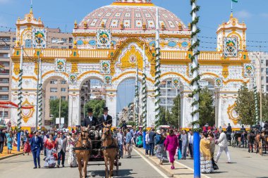 Seville, İspanya - 5 Mayıs 2019: Sevilla, İspanya 'da 5 Mayıs 2019 tarihli Nisan Sevilla Fuarı sırasında ana kapının önünde bir at arabası taşıyan adamlar