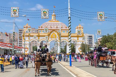 Seville, İspanya - 5 Mayıs 2019: Sevilla, İspanya 'da 5 Mayıs 2019 tarihli Nisan Sevilla Fuarı sırasında ana kapının önünde bir at arabası taşıyan adamlar