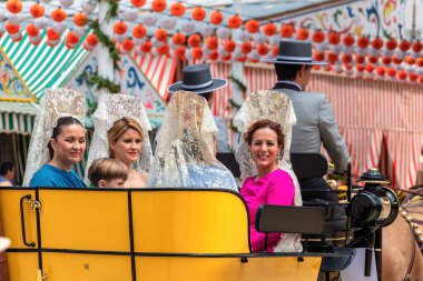 Seville, İspanya - 5 Mayıs 2019 Sevilla, İspanya 'da 5 Mayıs 2019 tarihli Nisan Fuarı sırasında at arabasında genç ve güzel kadınlar