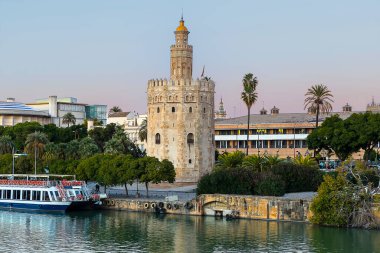 Altın Kule (Torre del Oro) Guadalquivir Nehri 'nin diğer yakasından gün batımında, Seville (Endülüs), İspanya.