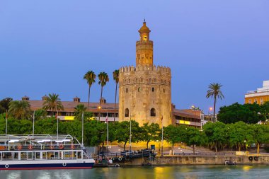 Altın Kule (Torre del Oro) Guadalquivir Nehri 'nin diğer yakasından gün batımında, Seville (Endülüs), İspanya.
