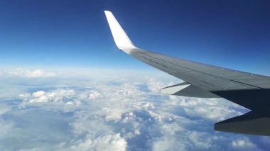 Uçaktan geçen koltuğun camından bulutlarla Gökyüzü görüntüsü