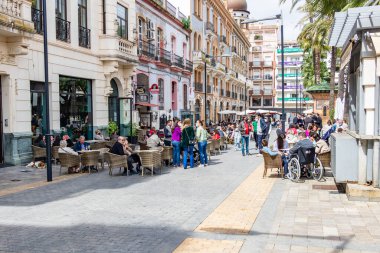 Huelva, İspanya - 1 Nisan 2021: Huelva 'nın Plaza de las Monjas (Nuns Meydanı) meydanındaki bir kafe ve barın terasında oturan insanlar, covid-19 nedeniyle koruyucu yüz maskesi takıyorlar. Huelva, İspanya