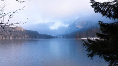 Bavyera 'daki Alpsee' nin üzerinde muhteşem Mavi ve Mor Işıklı Güzel Manzara - Moody Kış Manzarası 'nda Göl Resmi. Sisli bir gün ve çok kaliteli bir fotoğraf.