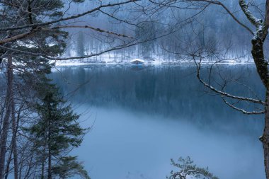 Güzel manzara, Bavyera 'daki Alpsee' nin üzerinde büyük ışıkla dolu Küçük Kulübe, boş Uzay Yüksek kalite fotoğraf ile yansıtılıyor.