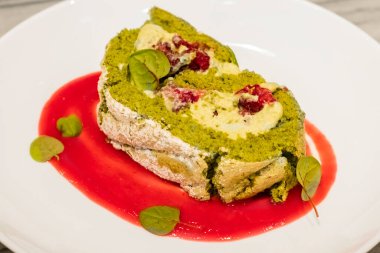 Şerbetli taze ahududulu şam fıstıklı tatlı. Tabakta turta