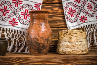 Tahta bir rafta süt için eski Rus kil krynka 'sı. El yapımı seramik tabaklar