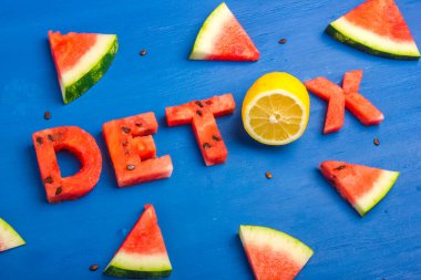 Kelimeler karpuz ve limondan yapılmış. Diyet konsepti, vücut temizliği, sağlıklı beslenme. Mavi arkaplan