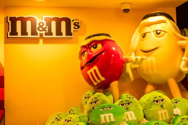 Dubai, Birleşik Arap Emirlikleri - 1 Ekim 2019 - M & Ms. Çikolata markasının karakteristik maskotu. Şekerleme arka planında. M & M 'ler Mars tarafından üretilen renkli düğme şekilli çikolatalardır