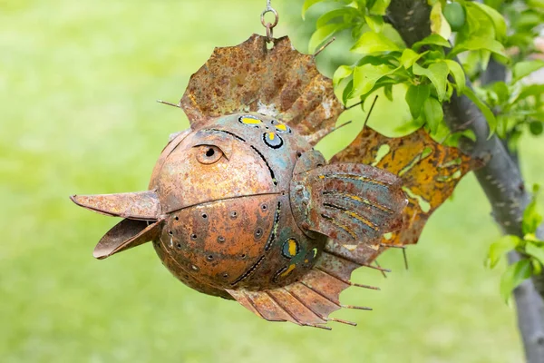 Paslı metal balıklar ağaca basıyor. Kolye süslemesi. Hediyelik eşya satışı. Komik el yapımı balık.