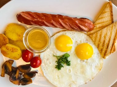 Sosisli sahanda yumurta ve tabakta tost. Düz yatış tarzı. Lezzetli kahvaltı.