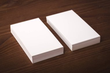 Tahta bir masada iki deste kartvizit şablonu. Şirket kimlik sunumu için kartvizit