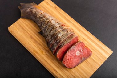 Lezzetli tütsülenmiş balık pembe somon, dilimlenmiş, kesme tahtasında. yakın plan