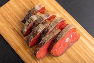 Servis tahtasında füme balık parçaları. Masaya güzel bir sunum. Balıklar yakın.