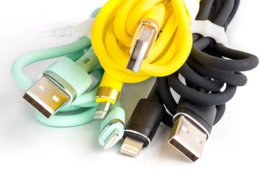 Beyaz arka planda bir cep telefonunu şarj etmek için renkli usb kabloları. Cep telefonu aksesuarı. yakın plan
