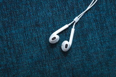 Mavi arka planda beyaz kulaklıklar. Metin için alanı kopyala