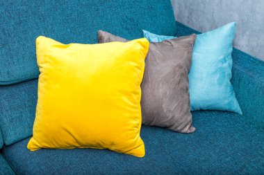 Dekoratif detaylar ve iç mekandaki elementler. Mavi bir kanepede renkli yastıklar. Yakın plan.