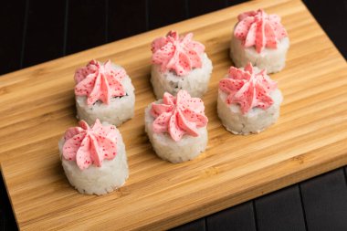 Bambu tabağında yuvarlanıyor. Ahşap arka plan. Japon yemeği servisi. Yakın plan.