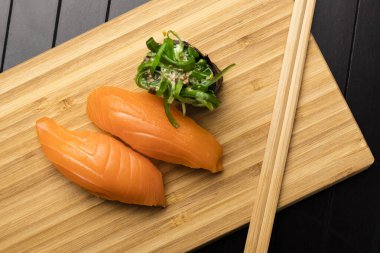 Bambu paketleme tahtasında somonlu suşi. Japon yemeği servisi. Üst görünüm