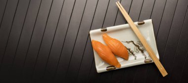 Çubuklu somonlu suşi. Üst Manzara. Metin için yeri olan ahşap masa, boşluğu kopyala