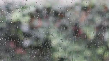 Yağmur damlaları pencereden aşağı kayar.
