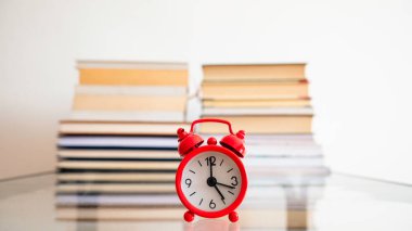  Kitapların önündeki kırmızı çalar saat..