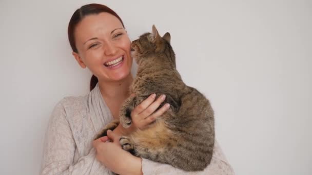 白人女人拥抱着并亲吻舔她脸颊的猫 — 图库视频影像
