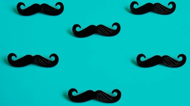 Black mustache on a blue background.  Father's day or man health concept. No shave November month. 