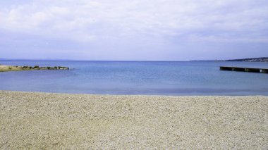 Tropik plaj, deniz ve bulutlu gökyüzü.