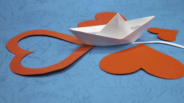 Bir origami kağıt gemisi kırmızı kalplerin içinden geçer. Hayatta aşkı bulmanın bir metaforu. Yelken sevgisi.