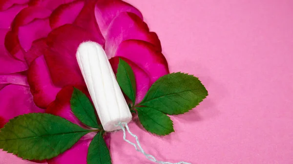 ピンクの背景にバラの葉と花弁がタンポンで飾られています — ストック写真