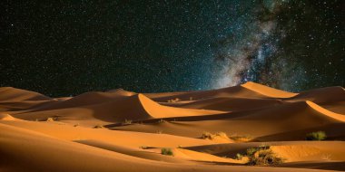 Dubai 'deki gece çölündeki kum tepelerinin üzerinden samanyolu, uae