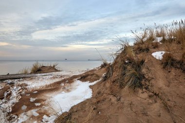 Kışın Letonya 'nın Riga limanının girişine yakın Baltık Denizi' nin kumlu kıyıları