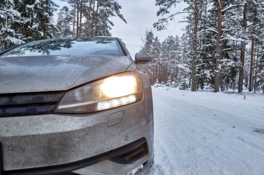 18 Ocak 2021, Engure Letvia: Kışın ormanda karlı yolda giden araba