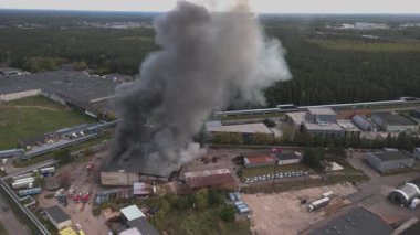 Riga, Letonya 'daki Staiceles Caddesi' ndeki büyük bir endüstriyel yangının hava görüntüsü, 10 Temmuz 2024 'te çekildi. İHA görüntüleri, yanan bir depodan yükselen yoğun siyah duman bulutlarını gösteriyor. İtfaiye araçları ve acil durum ekipleri çalışıyor..