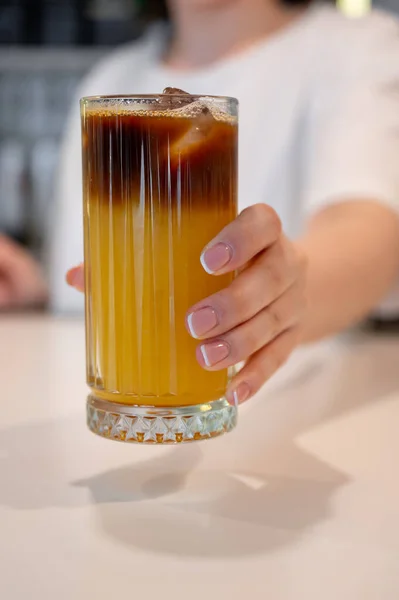 Elinde portakal suyu ve kahveyle soğuk içecek.