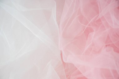 Yumuşak beyaz ve pembe tül kumaşın soyut arkaplanı. Düğün, gelin ya da romantik kadın tasarımları için hassas ağ dokusu
