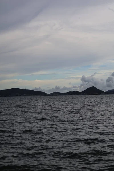 Norveç 'te bulutlu gökyüzünün altında bir denizin dikey çekimi