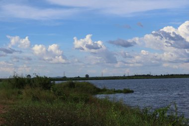 Göl ve mavi bulutlu gökyüzü ile güzel bir manzara.