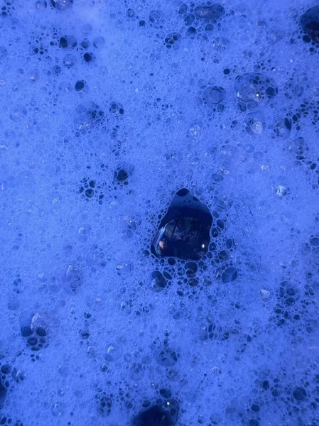 Pastel veya beyaz bir yüzey üzerinde yüzen yumuşak, şeffaf kabarcıklar içeren sanatsal bir soyut arkaplan.