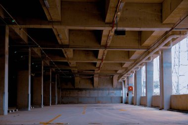 Temiz, iyi ışıklandırılmış kapalı otopark. Organize park alanları, beton yapılar ve yön işaretleri..