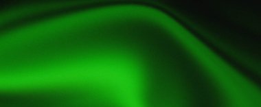 Yumuşak kıvrımlarını gösteren zengin yeşil kumaştan oluşan bir yakın çekim ve ince bir parıltı onun ince desenli yüzeyini aydınlatıyor..