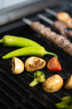 Barbeküde ızgara sebze ve mantar.