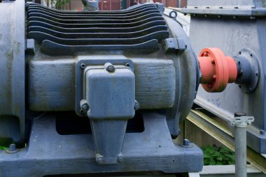 Maviyle boyanmış, soğutucu yüzgeçleri ve cıvataları olan endüstriyel bir konutun yakın plan fotoğrafı. Görüntü, mekanik tasarım veya endüstriyel teknoloji için ideal olan metalik dokuyu ve hassasiyet mühendisliğini yakalar.